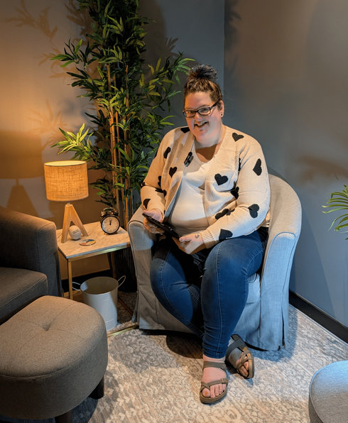 RN Psychotherapist, Stephanie Edmonds smiling, siting in a chair